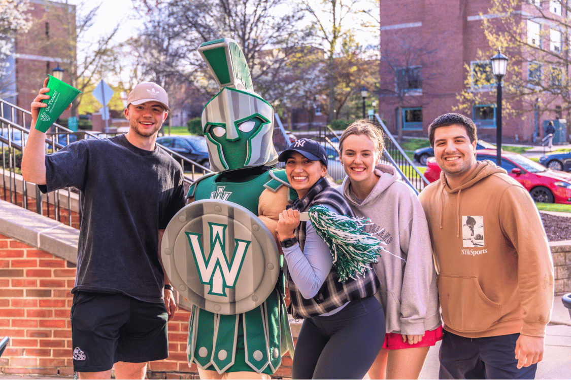 All In Recap Three students wave pompoms with Tommy Titan mascot on IWU campus