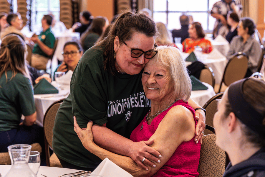Employee Recognition Two employees embracing during luncheon