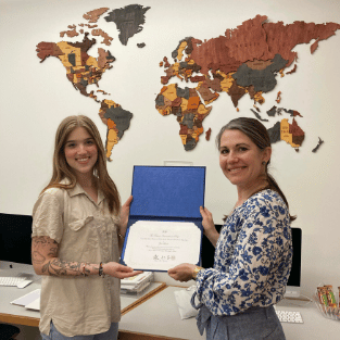 Hovde Zoe Hovde holding a certificate with Interim Provost and Dean of the Faculty Abbie Kerr