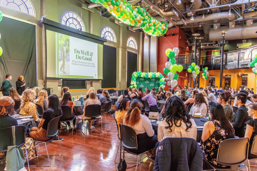 Do Well Do Good Students seated at tables surrounded by balloons during awards ceremony