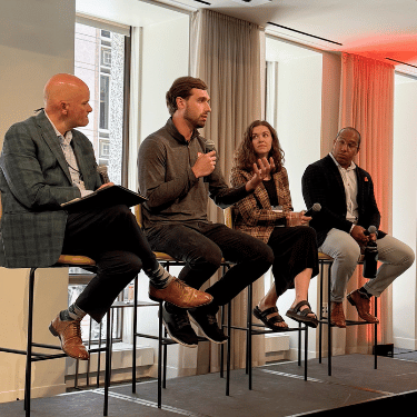 IWU alumni seated with microphones during an entrepreneurial panel in Chicago