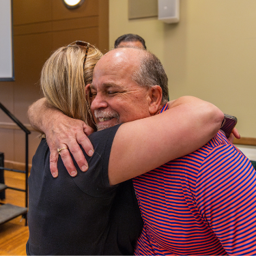 Bob Rogers hugs staff member