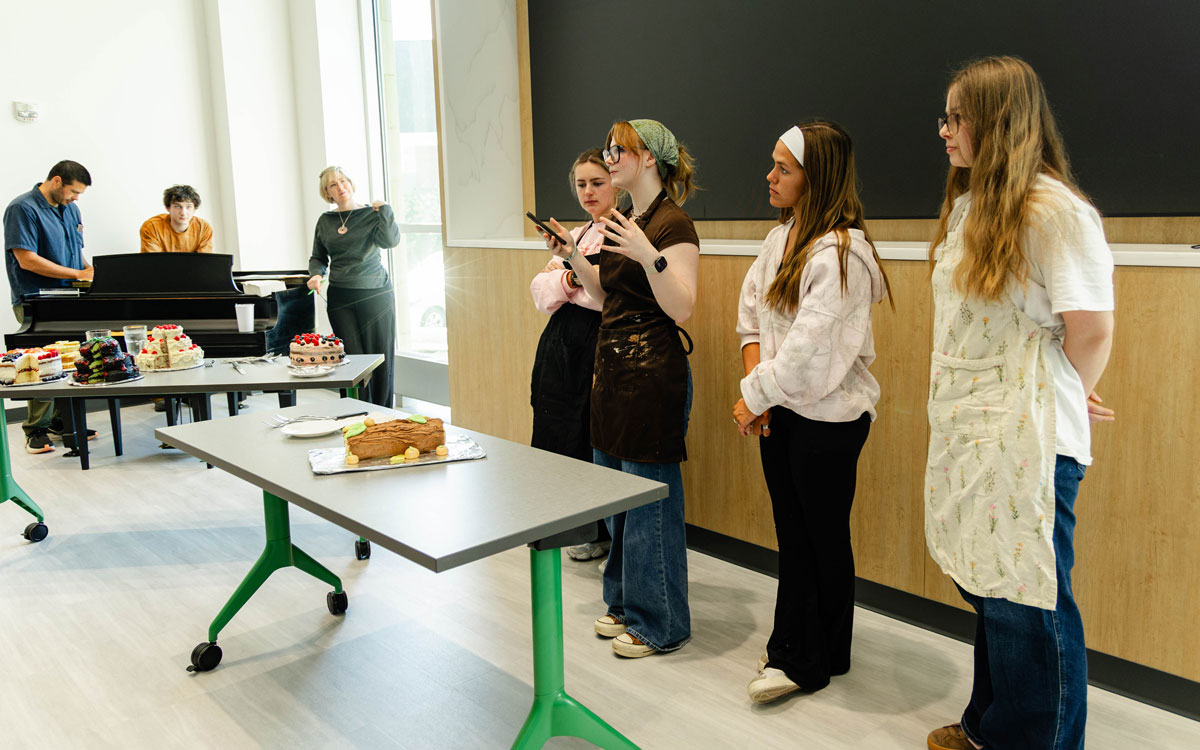 The yule log group explains their cake to the audience.