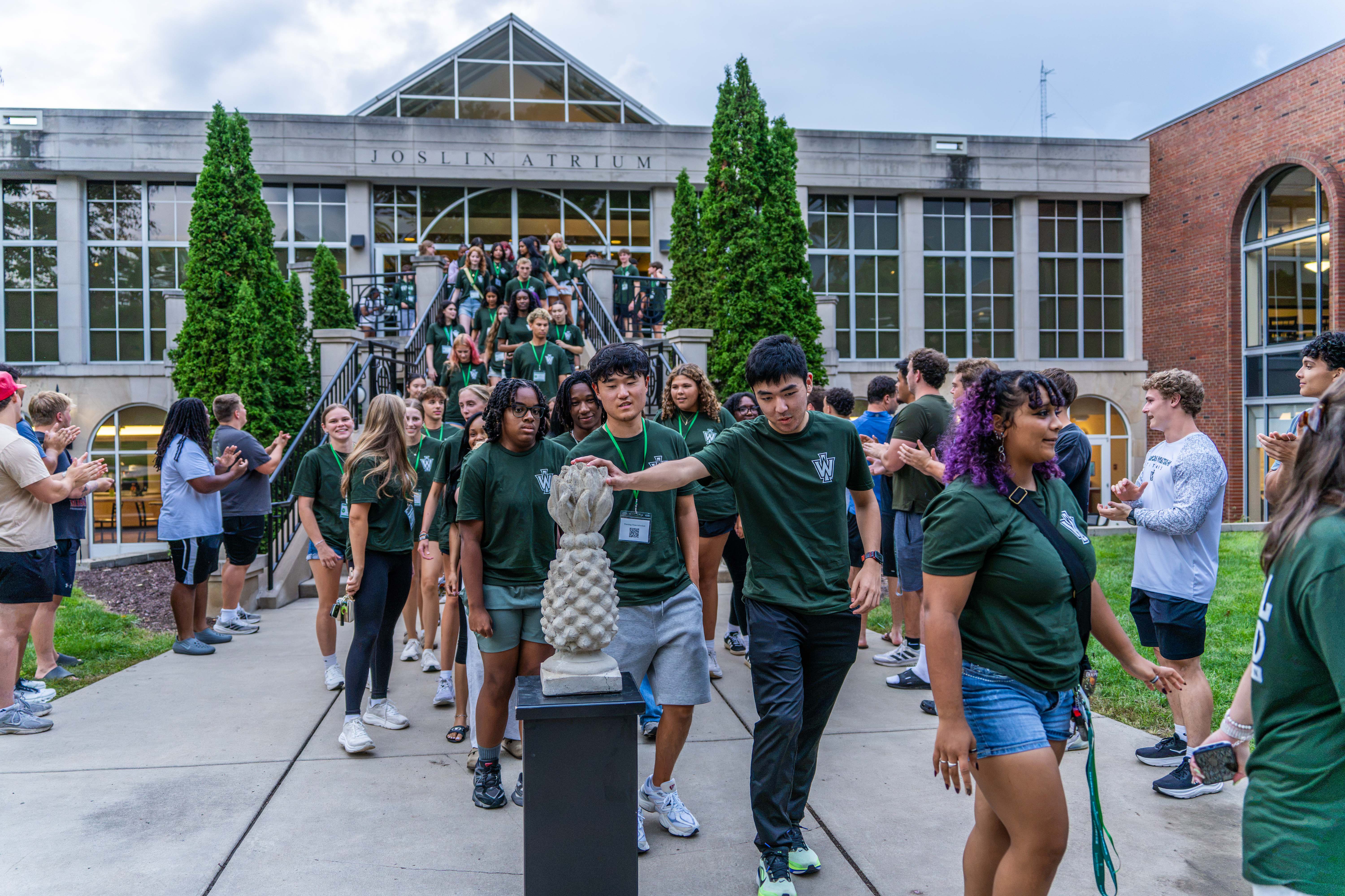 New students participate in the tradition of patting the pineapple.