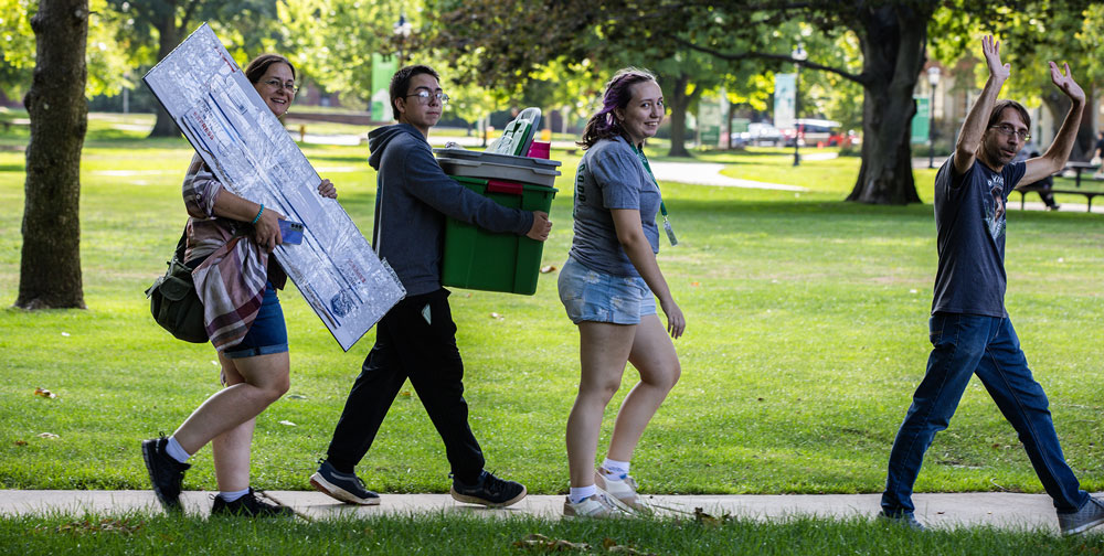 First year student and family carrying items to residence hall