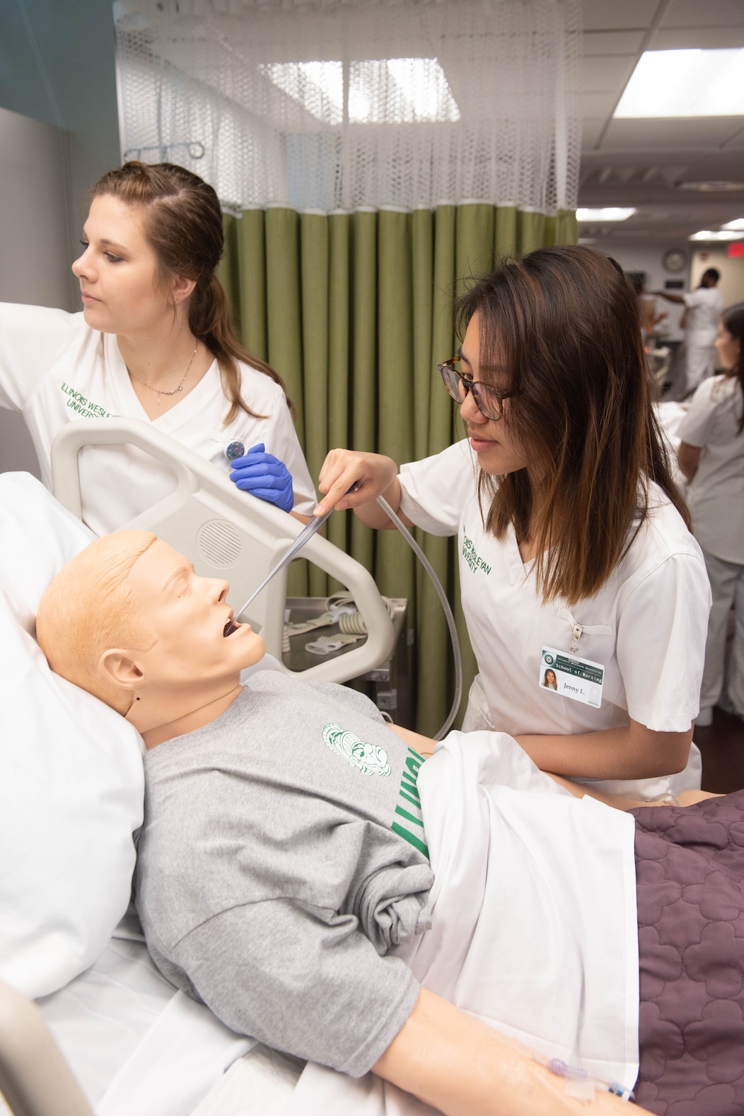 Nursing students practicing techniques on a dummy