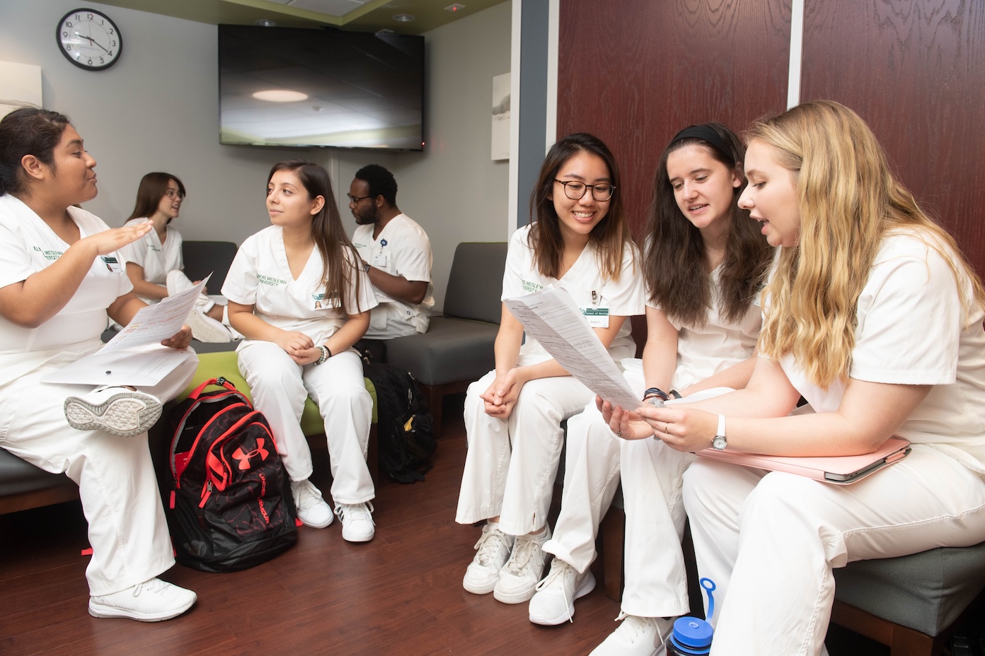 Nursing students sitting while discussing notes.